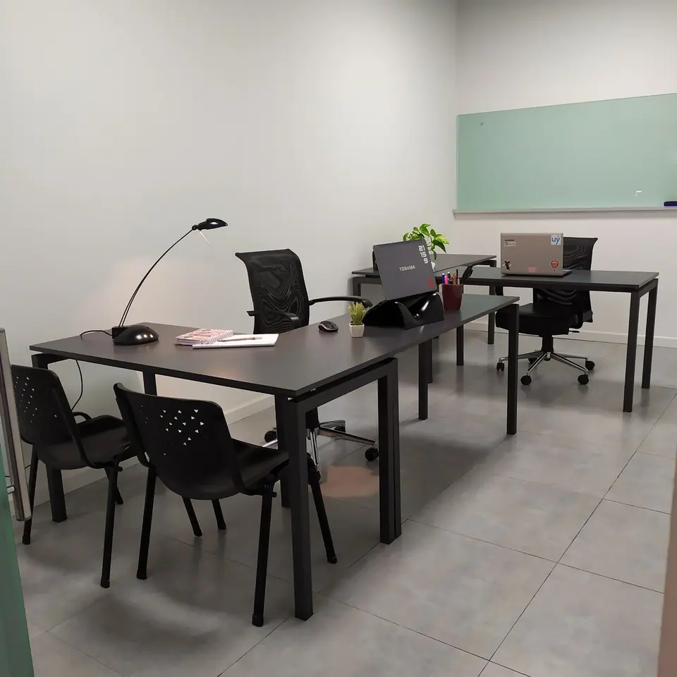 Oficina privada con escritorios y sillas para un equipo