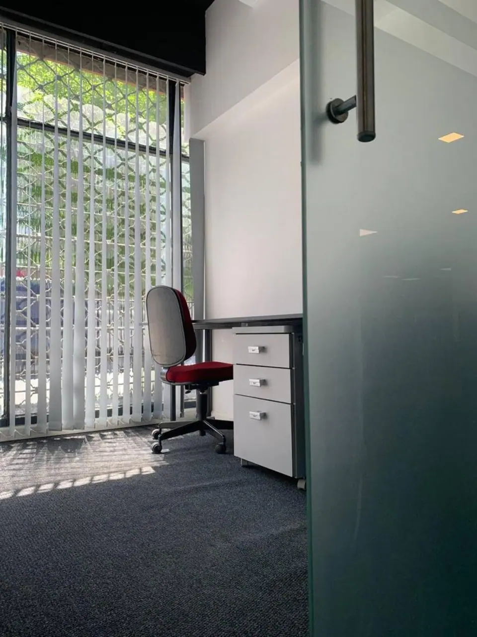 Oficina privada con ventana a la calle y puerta de vidrio